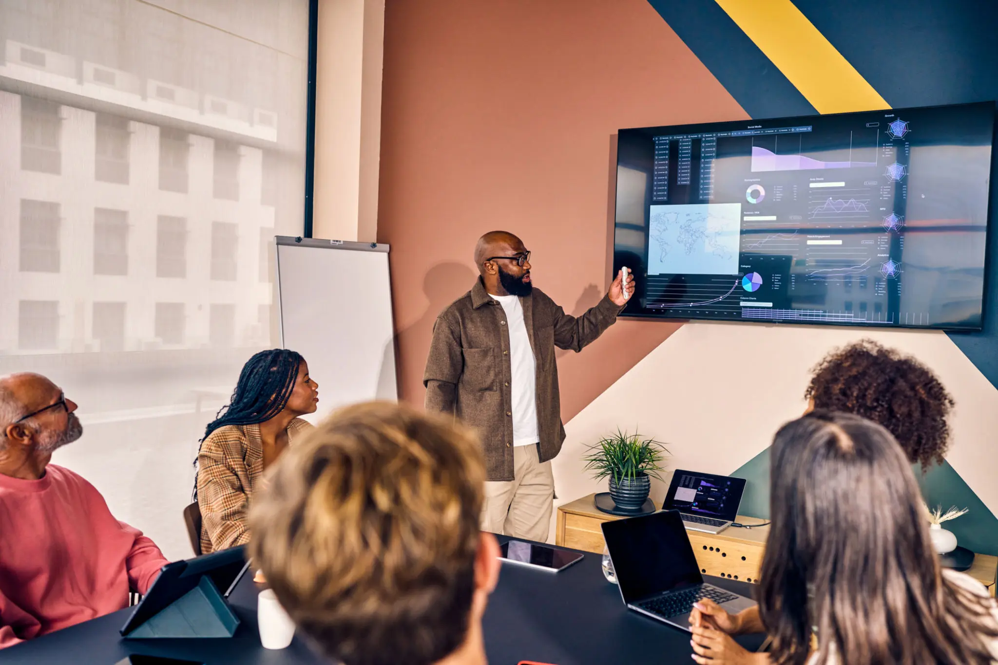 Multiracial business team in a meeting with data analysis presentation in a modern office. Corporate strategy and analytics concept