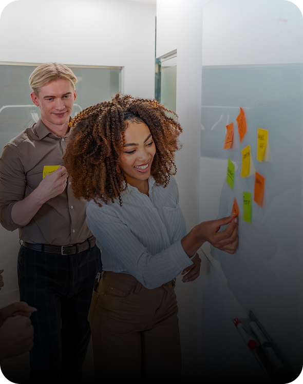 People collaborating with sticky notes on wall.