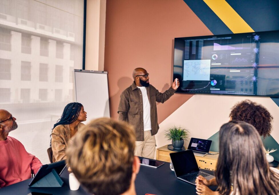 Multiracial business team in a meeting with data analysis presentation in a modern office. Corporate strategy and analytics concept